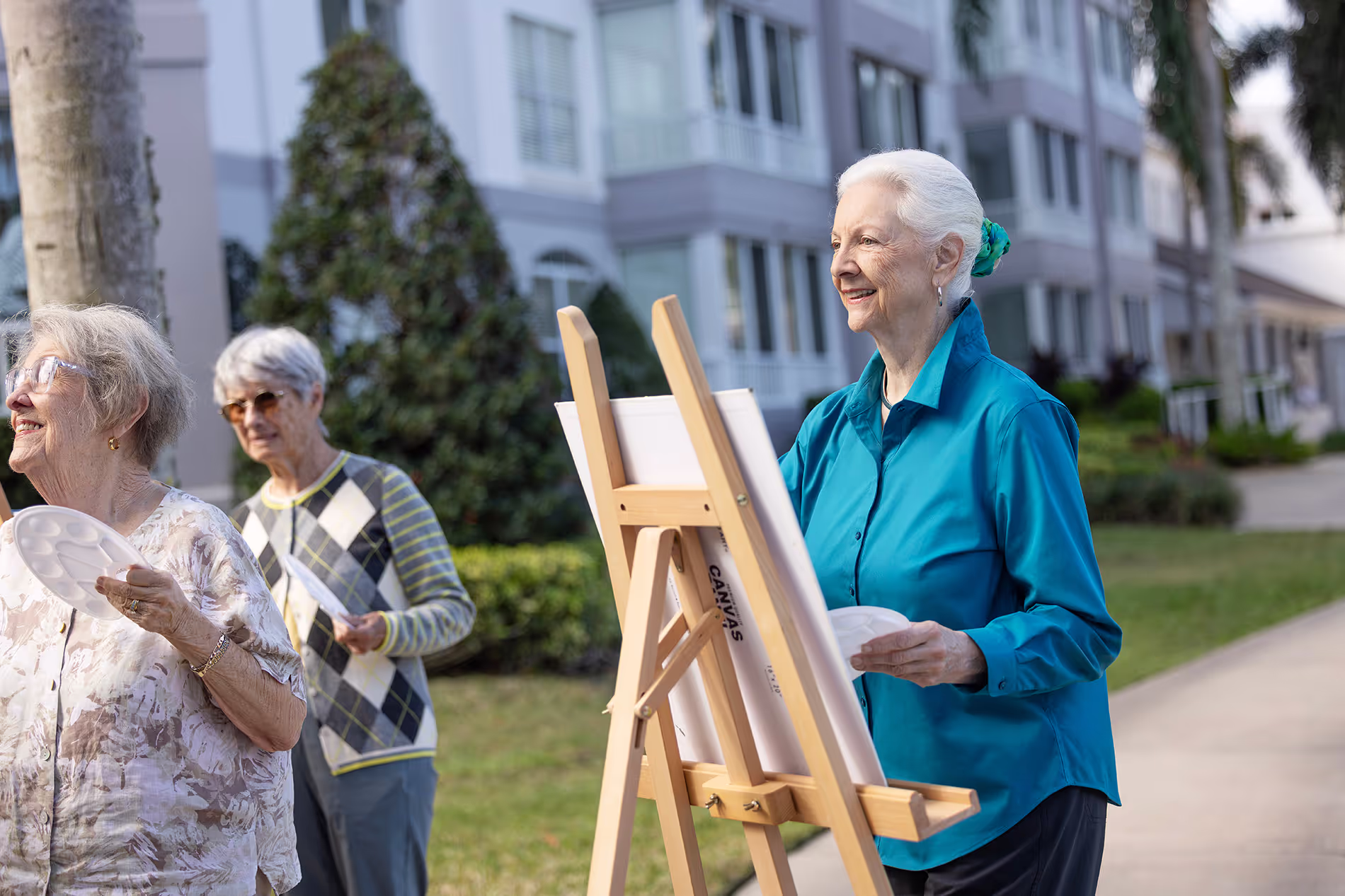 Senior woman painting outdoors on an easel, surrounded by nature and natural light, enjoying a peaceful and creative moment.