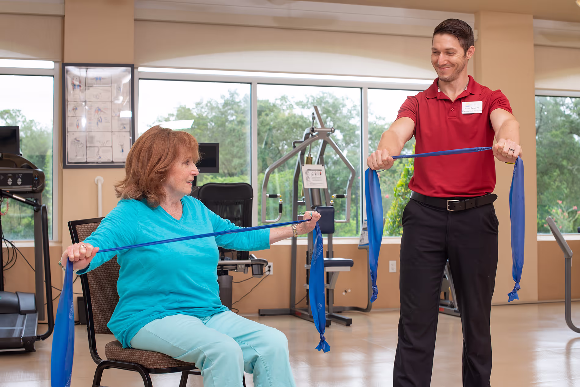 Older woman participating in a physical therapy session, guided by a therapist as she works on mobility and strength exercises in a supportive environment.