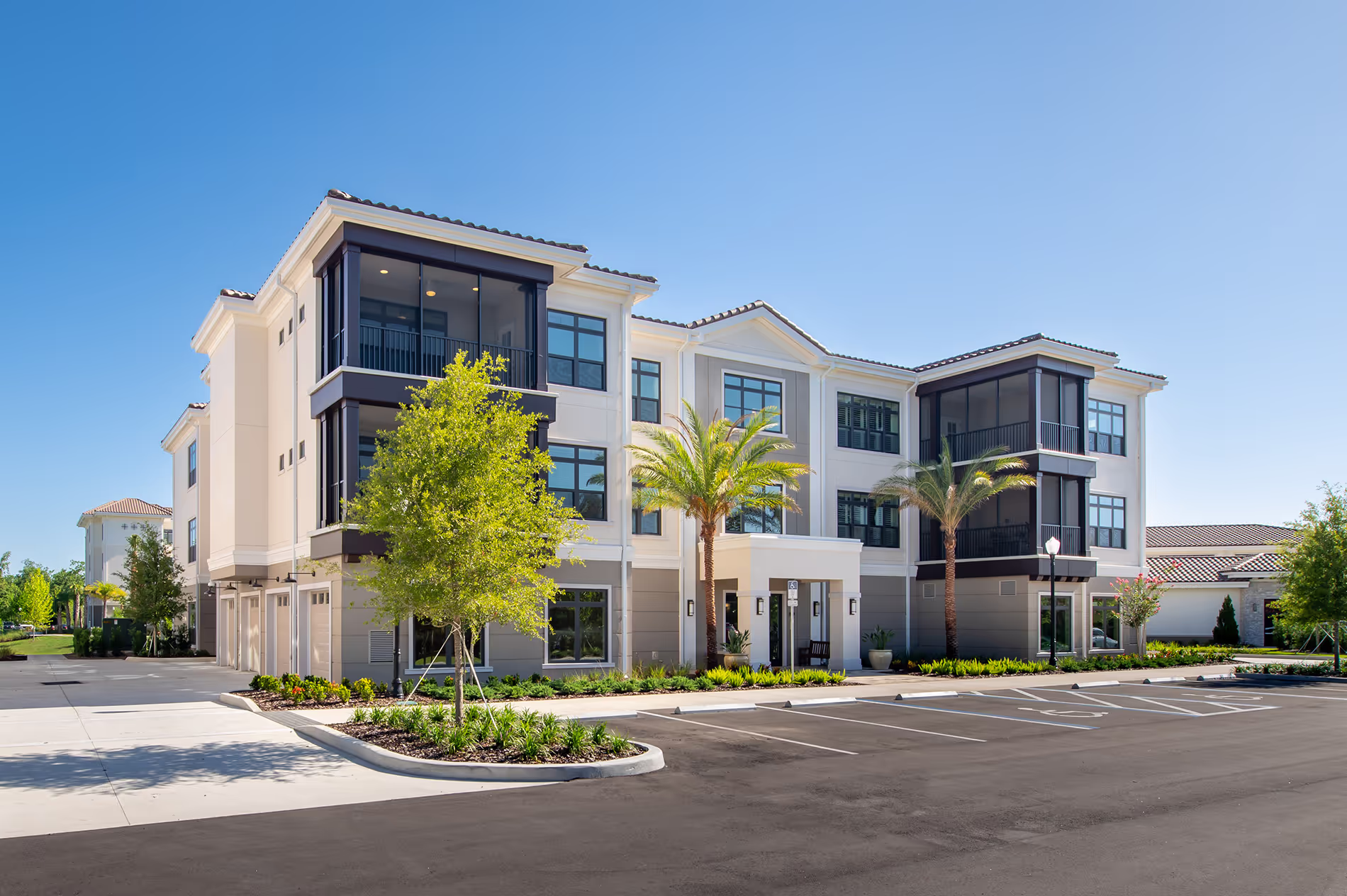Exterior view of one of the newest apartment buildings on the retirement community campus, featuring contemporary design and well-maintained landscaping.