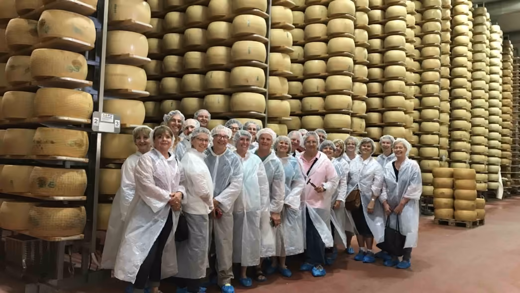 Culinary travelers inside an Italian cheese-aging facility