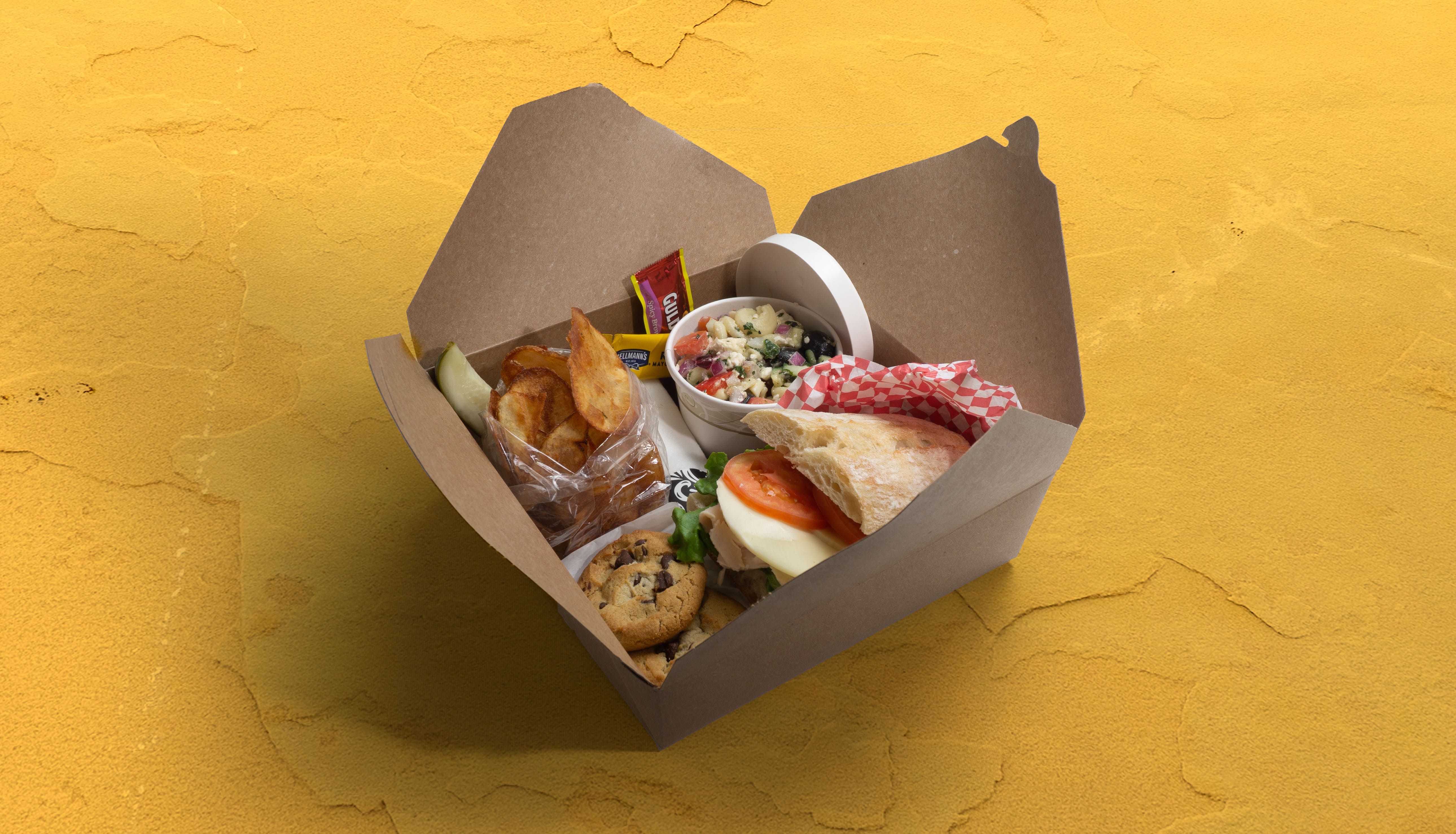 Boxed lunch with a sandwich, sides, and dessert