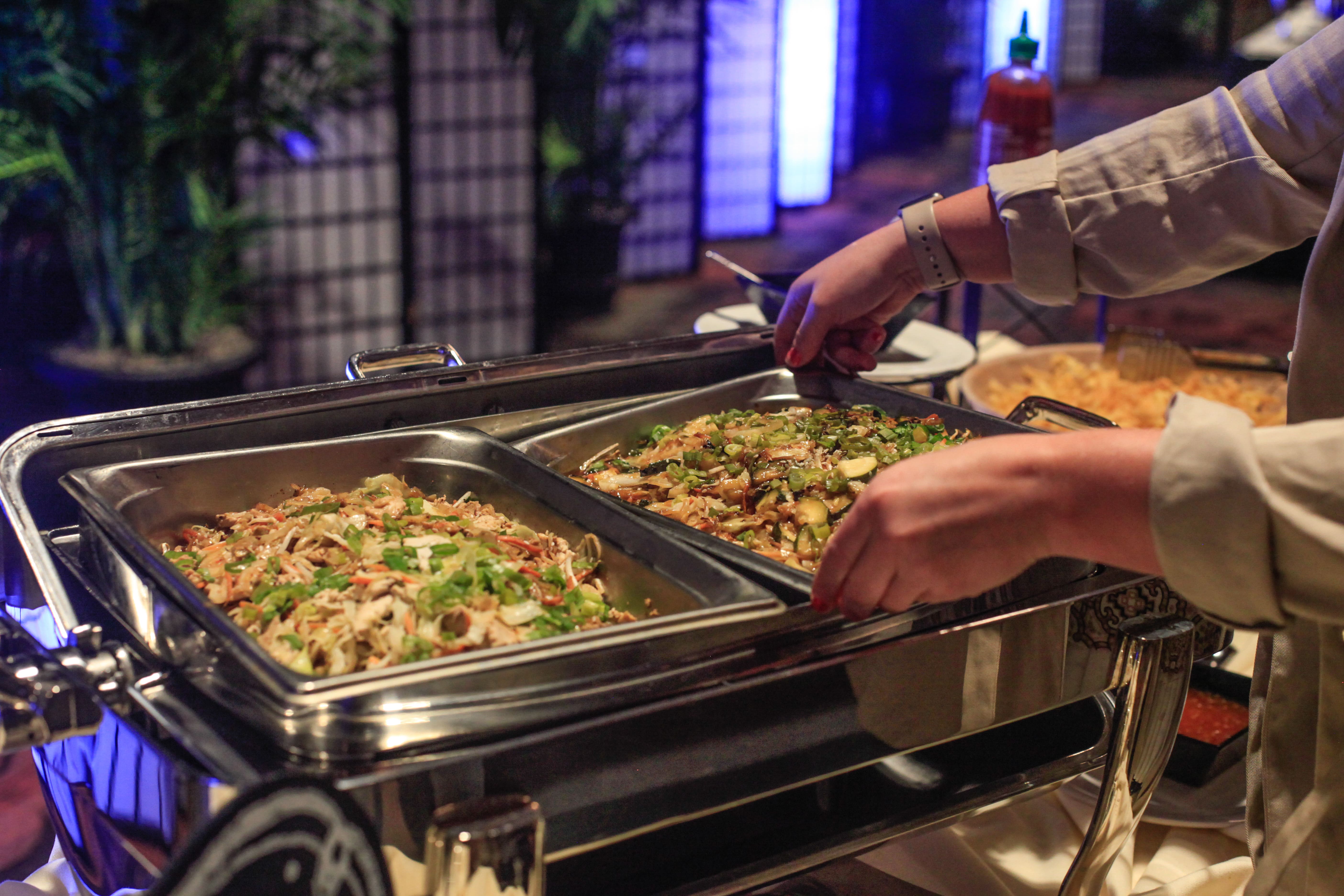 Server arranging buffet trays at a corporate event
