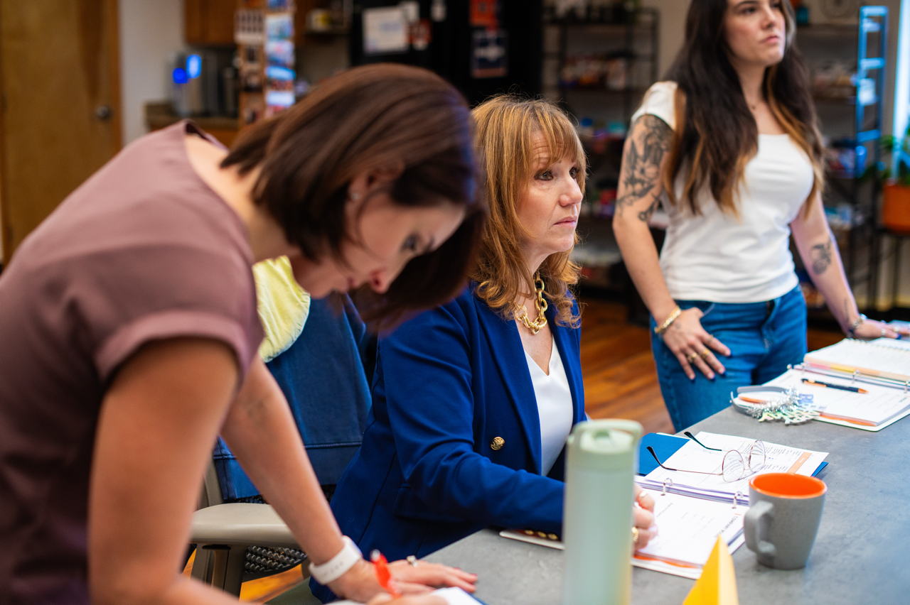 Three women collaborating at a workshop table