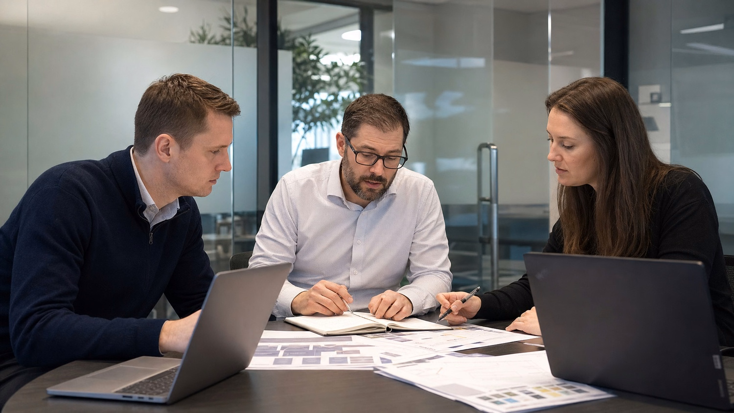 SMALL CONFERENCE ROOM An IT professional three people seated around a small