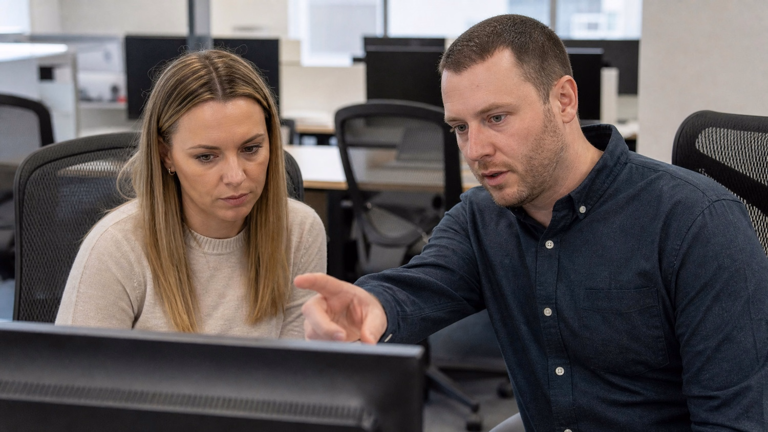 SIDE-BY-SIDE PAIR An IT professional two people seated side by side reviewin