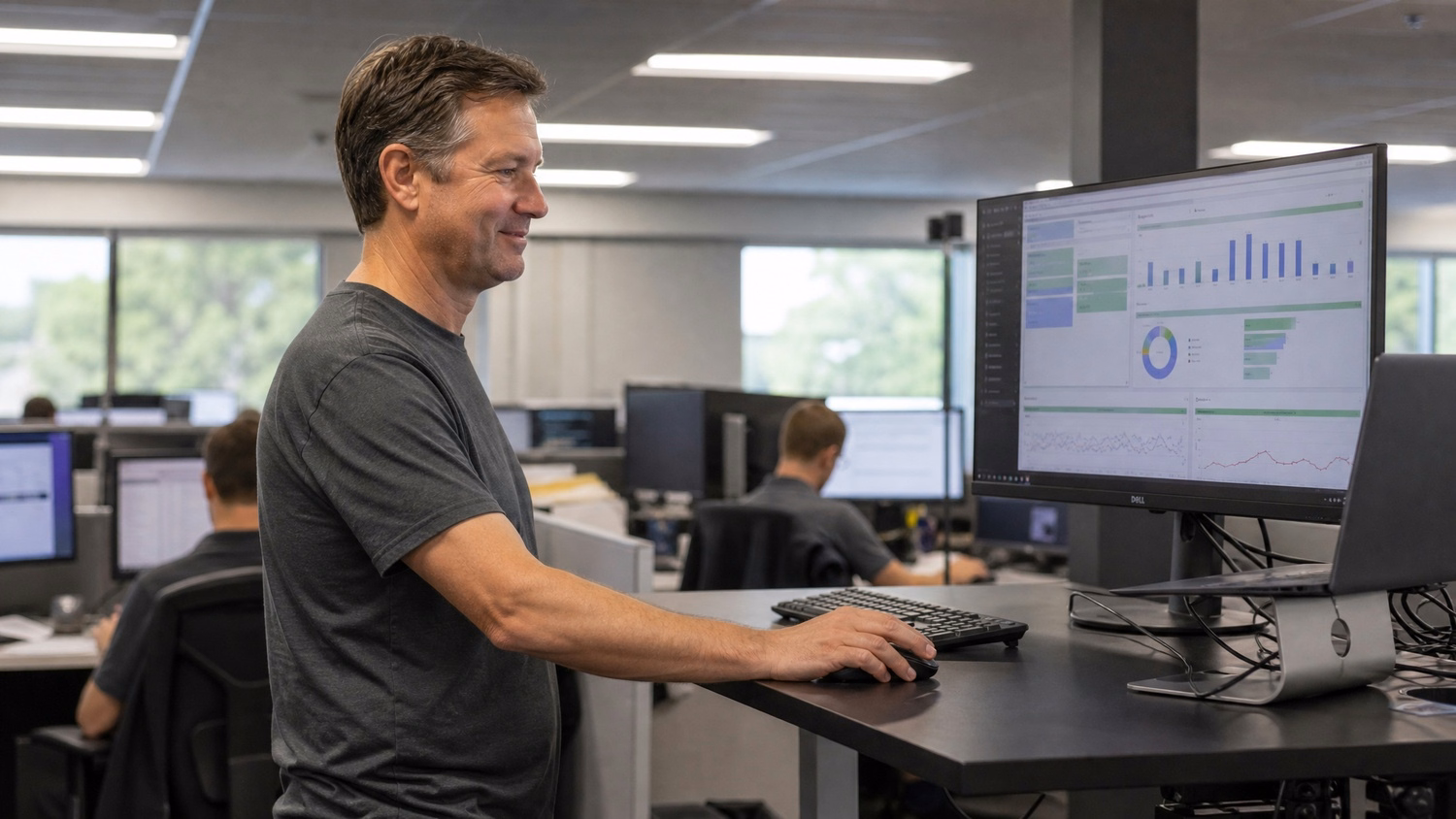 IT technician reviewing backup success dashboard at standing desk