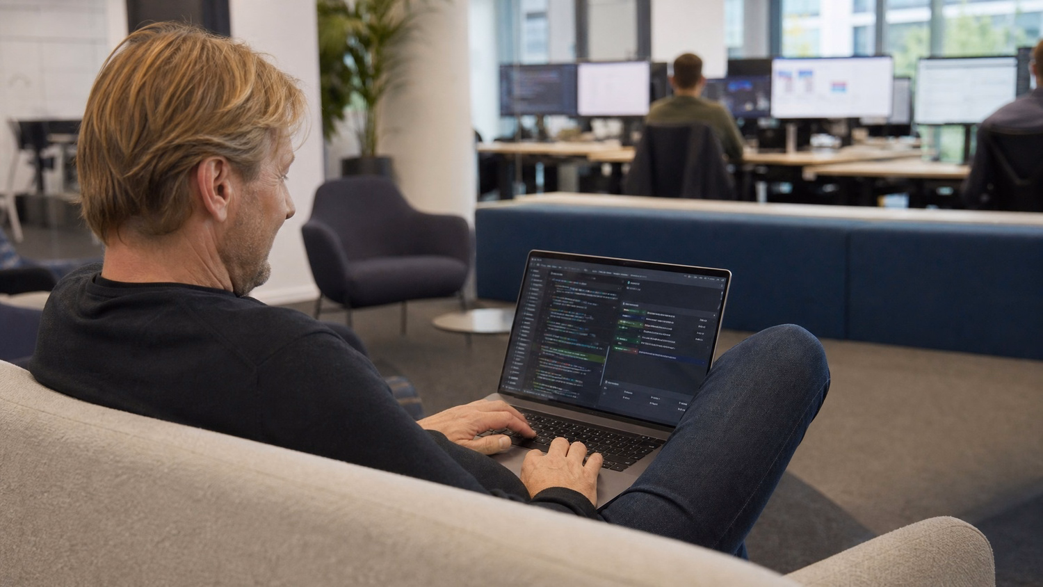 Man reviews vulnerability report on laptop in office lounge