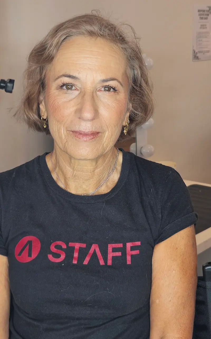 Mature woman with natural glam makeup and soft radiant finish looking at camera