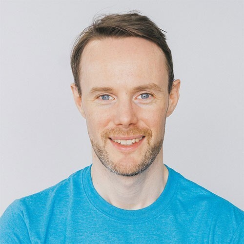 Photo of a man with dark hair wearing a blue shirt