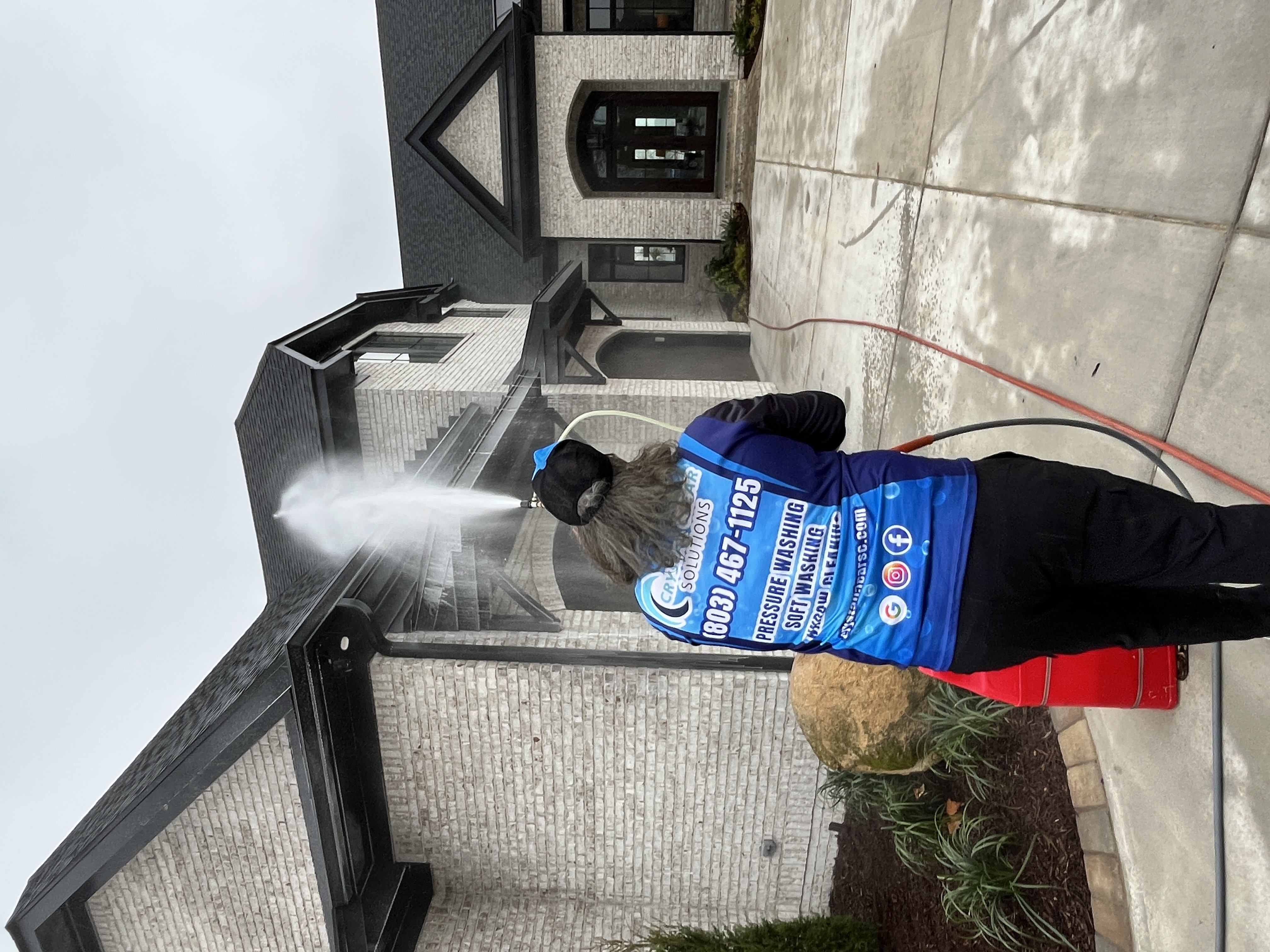 Crystal Clear employee cleaning roof on home