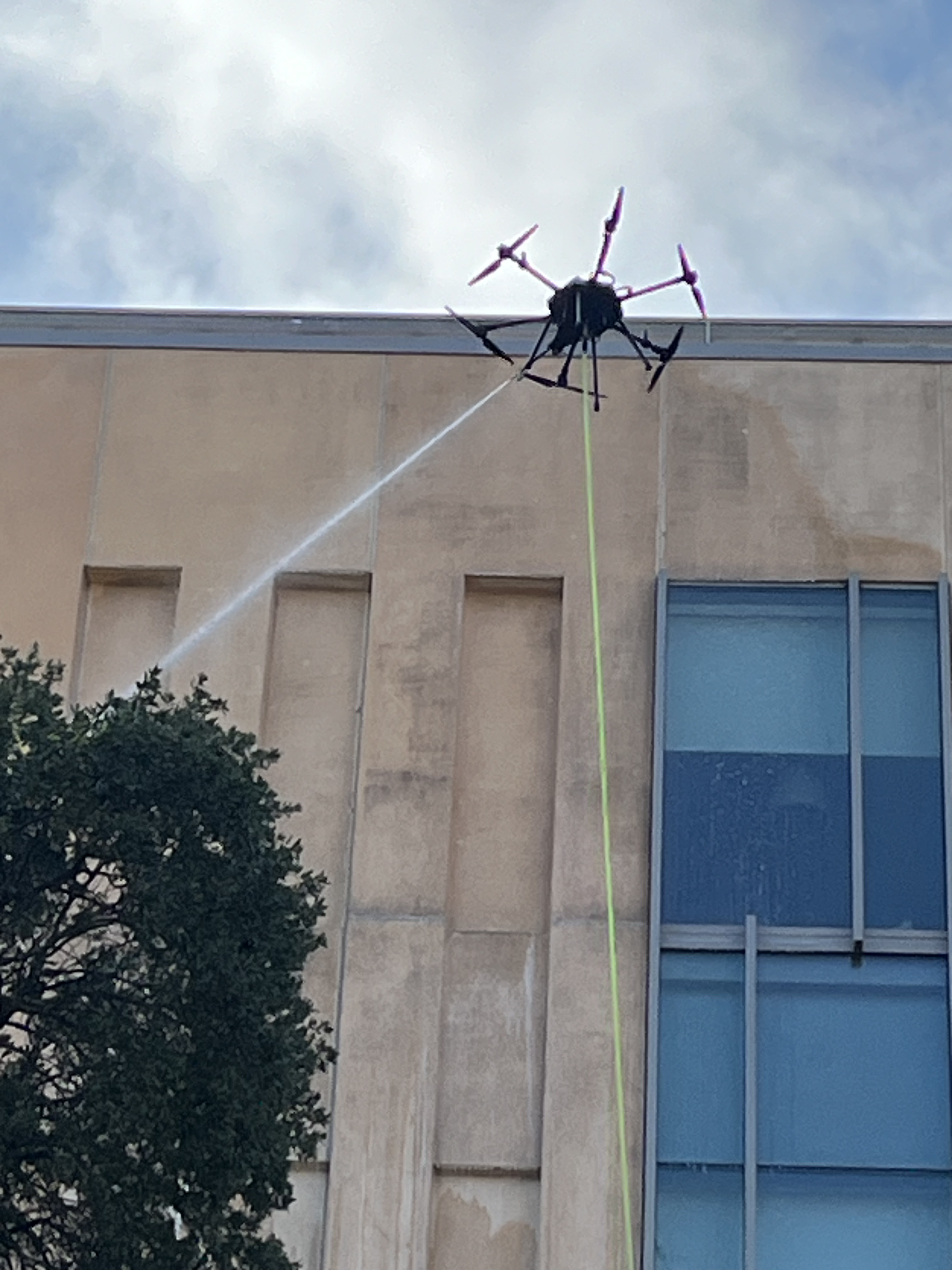 Drone cleaning exterior of building