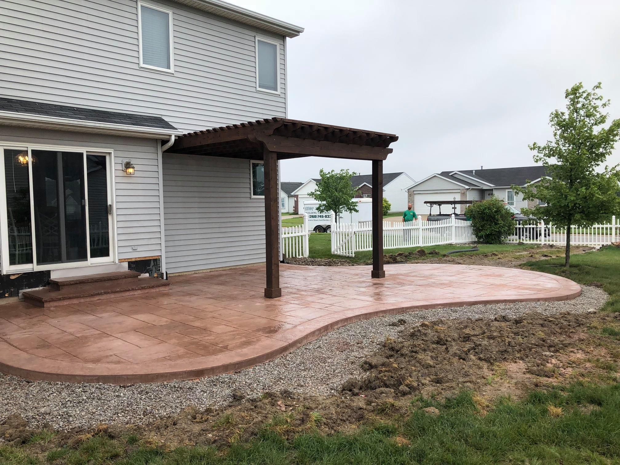 Pergola over stamped concrete patio by Knot Just Decks