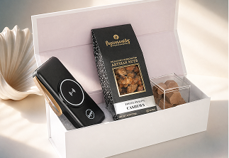 Luxury gift box containing a black handheld device, a box of artisan roasted cashews, and a small container of chocolates.