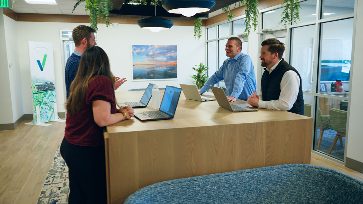 Woman explaining something to colleagues during a meeting in a modern office conference room.