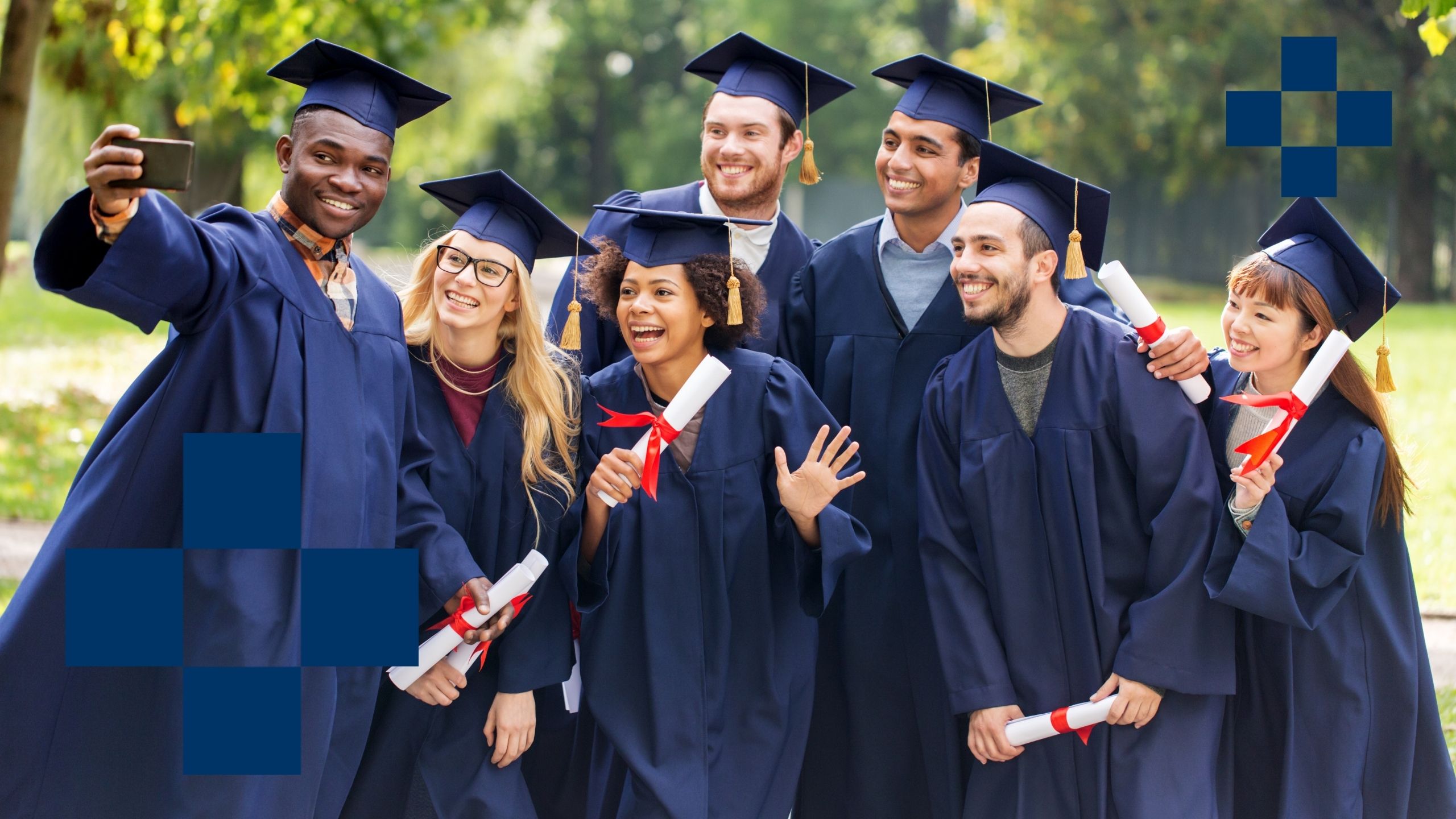 Group portrait of fourteen professionally dressed diverse men and women posing outdoors on a bench with a blurred background.