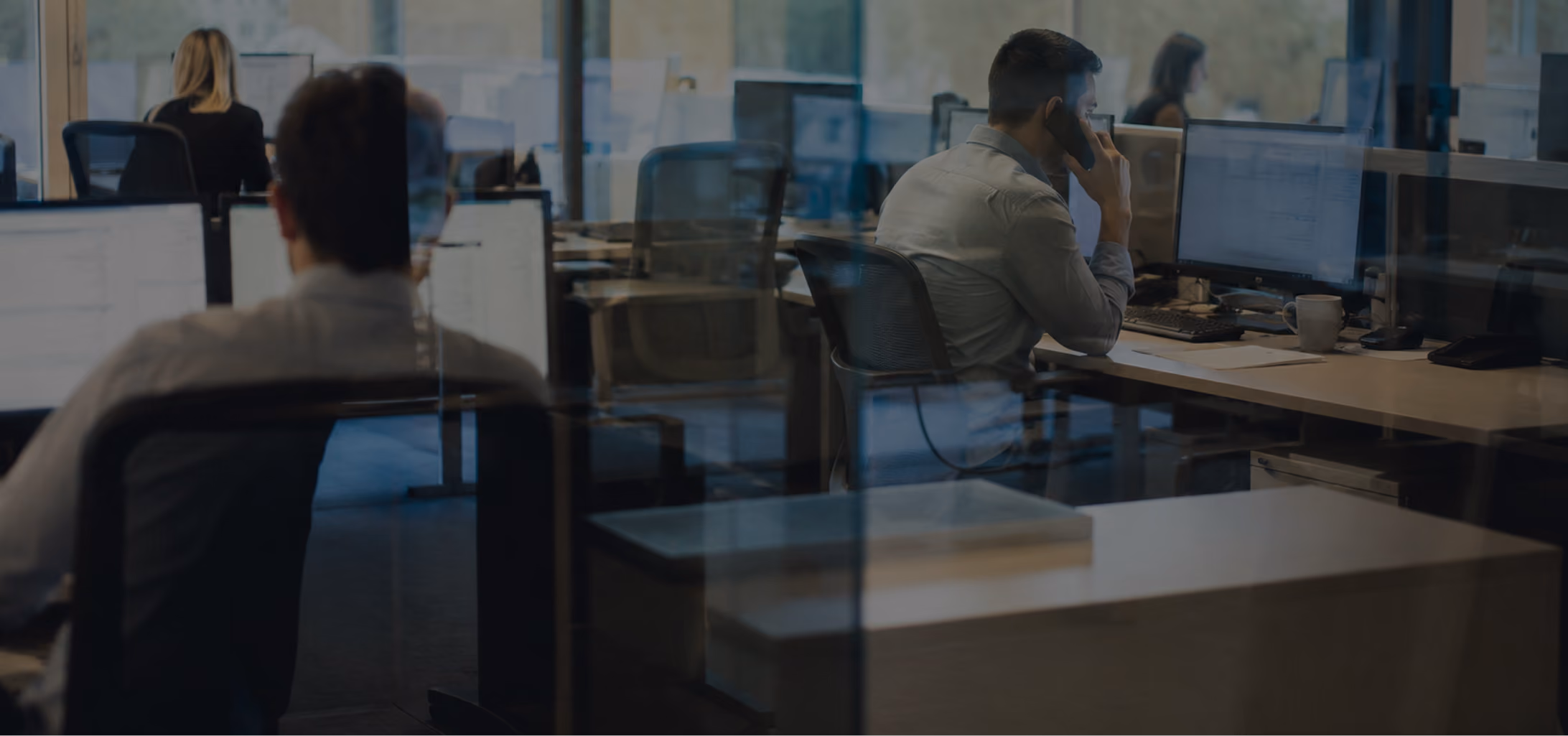 Customer service representative speaking on the phone while managing insurance claims in a modern office.