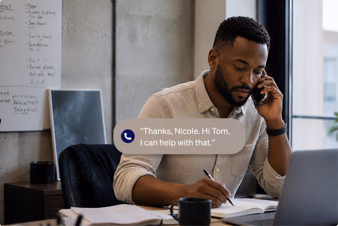 Customer service representative taking notes while speaking on the phone.