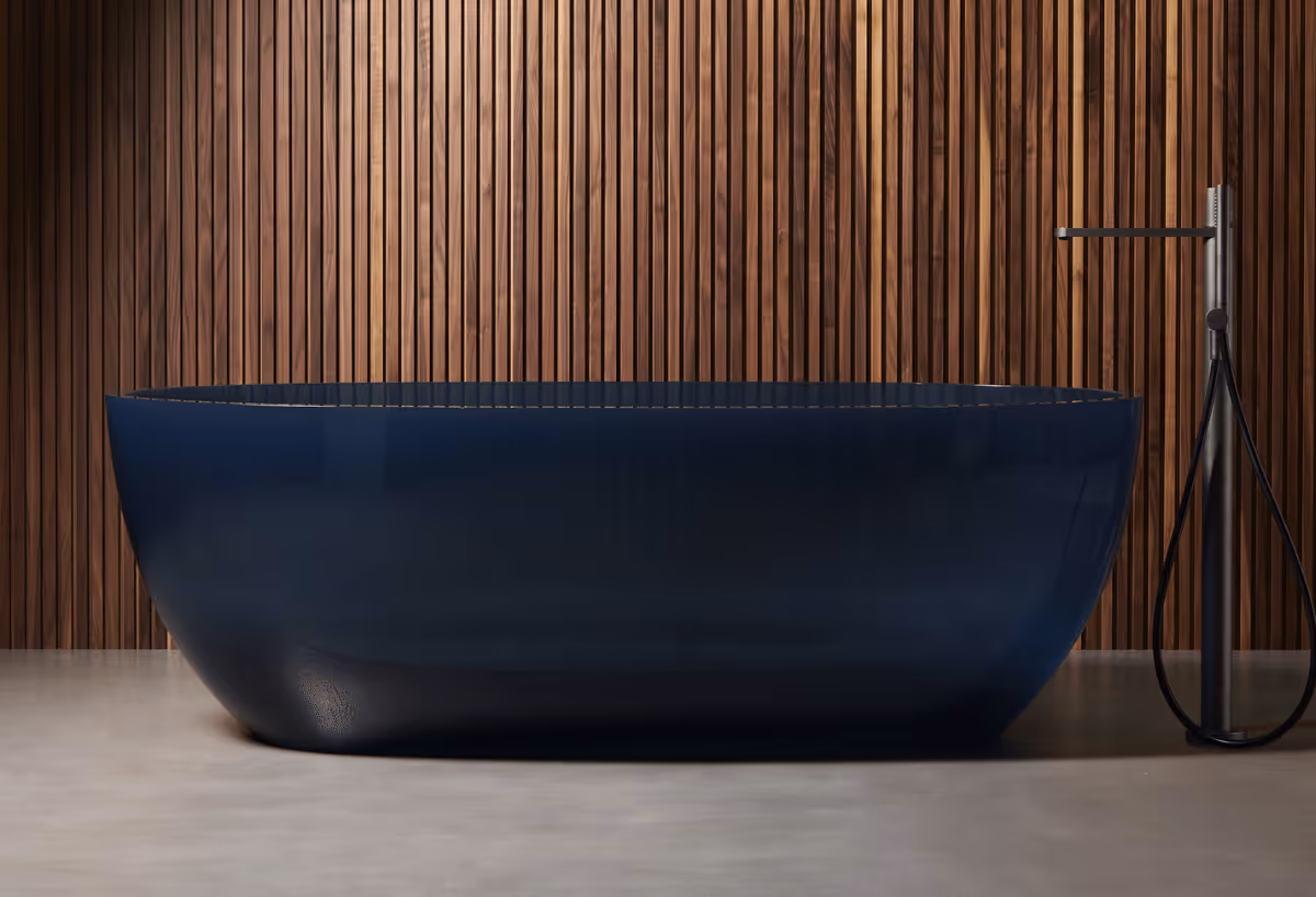 Vrijstaand donkerblauw bad van Antonio Lupi tegen een wand met houten latten