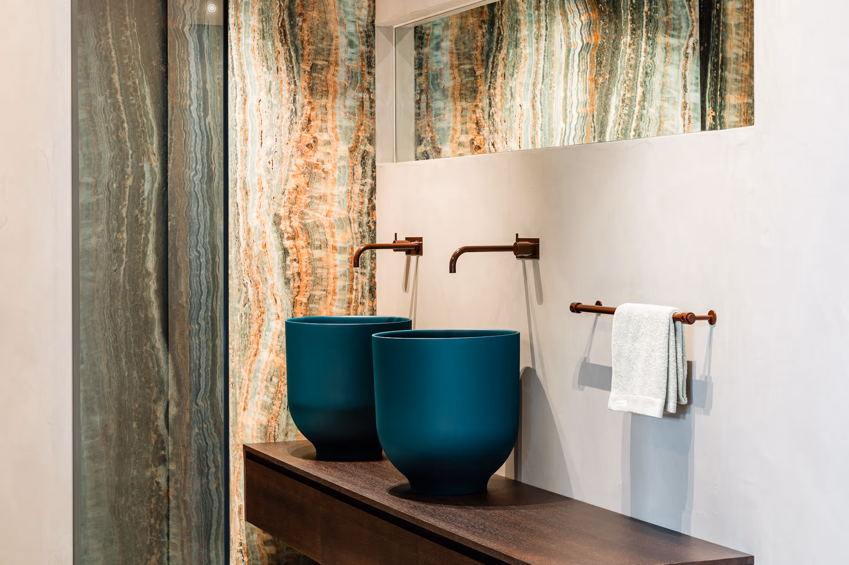 Urban Chique badkamer met turquoise kom-wastafels, koperkleurige kranen en marmerlook wand