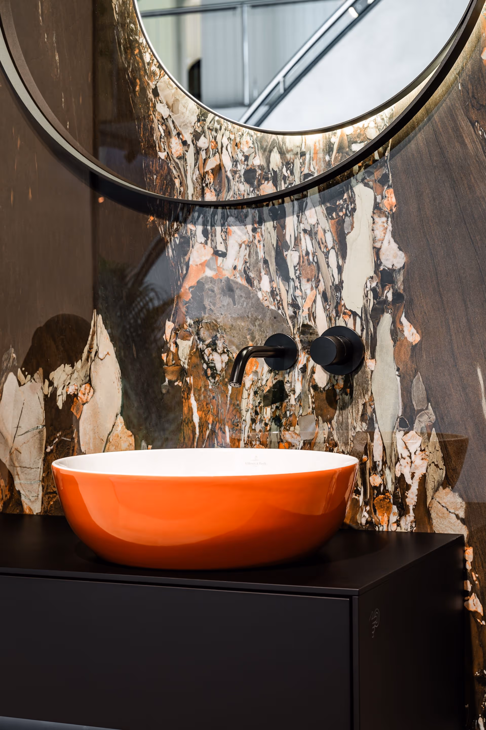 Eclectische badkamer met oranje kom-wastafel op zwart meubel en marmeren wand
