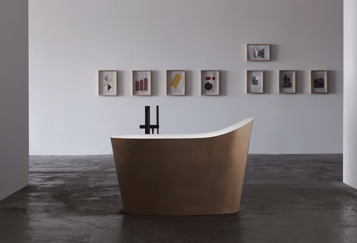 Antonio Lupi bronskleurig vrijstaand bad in een minimalistische ruimte met kleine kunstwerken aan de wand