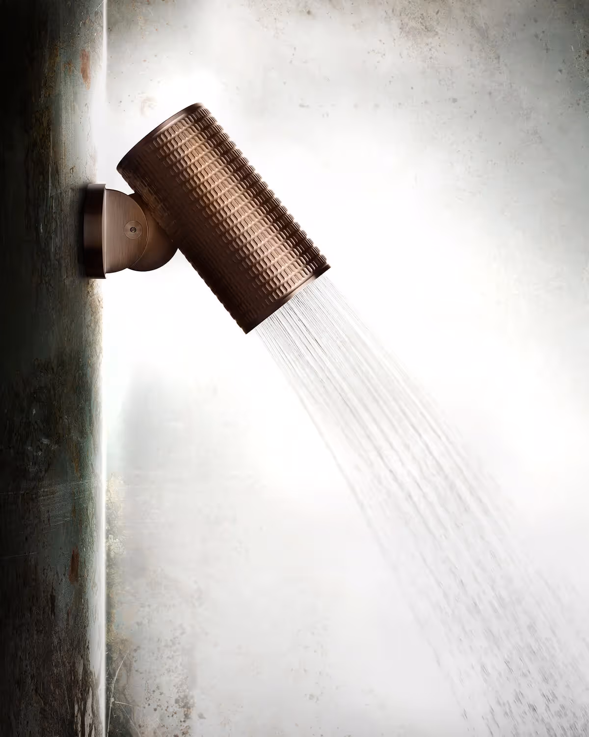 Gessi handdouche in geborsteld brons met waterstraal tegen lichte wand