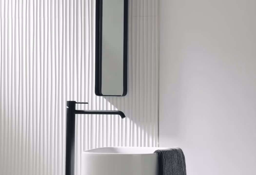 Porcelanosa grijze structuurtegel in douche met zwarte plank en ronde spiegel