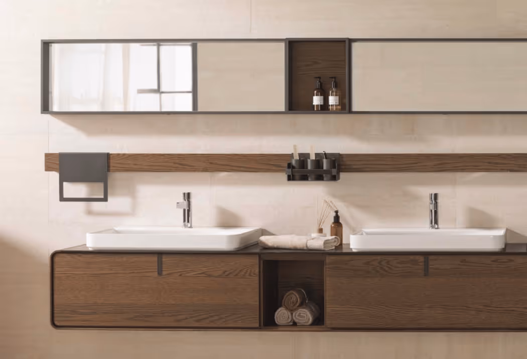 Porcelanosa tegelwand met metallic look bij chromen kraan en donkere handdoeken