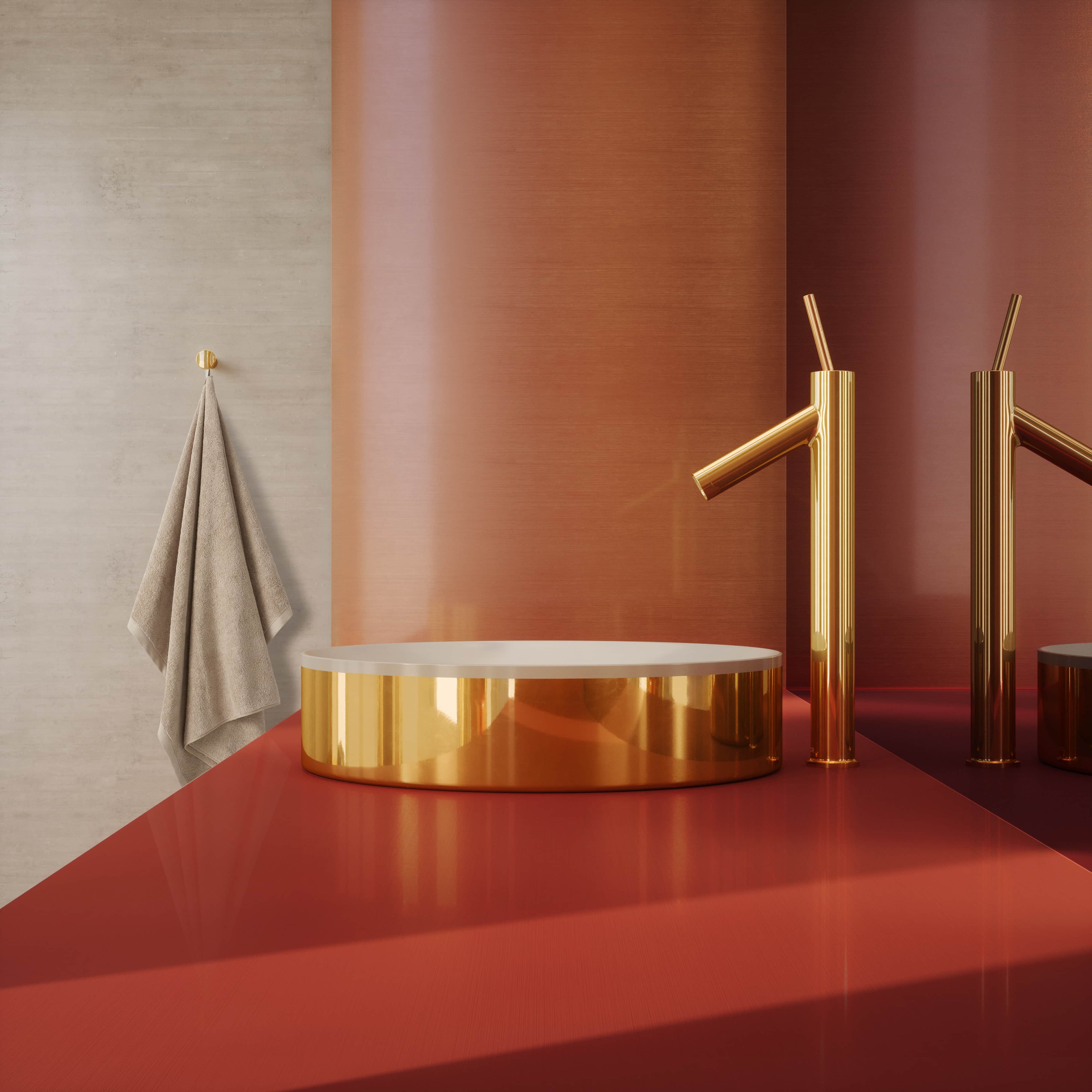 Axor Starck badrand en kranen in goud tegen een rood-oranje achtergrond met handdoek