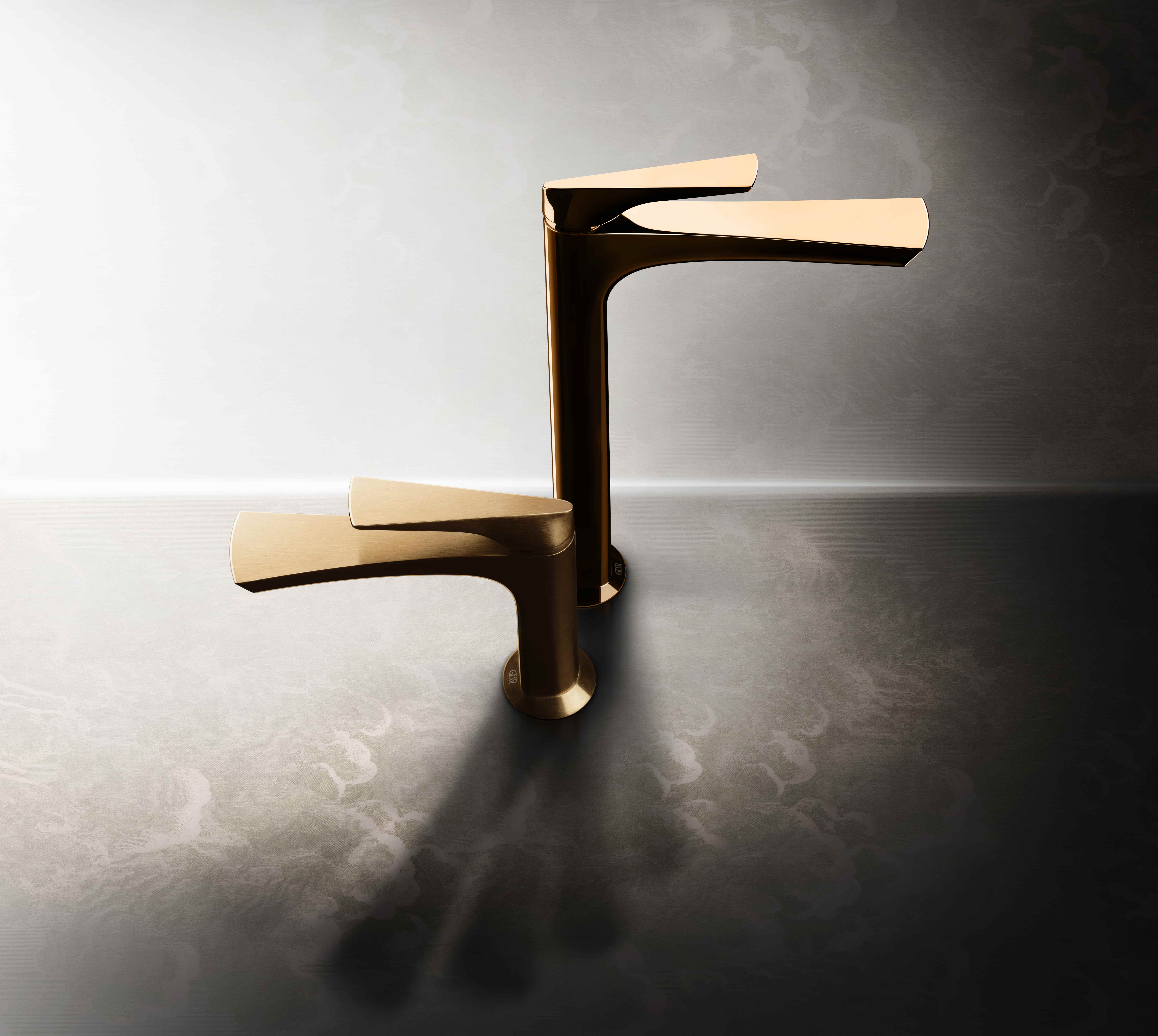 Gessi Ventaglio wastafelkranen in goud op een reflecterend oppervlak