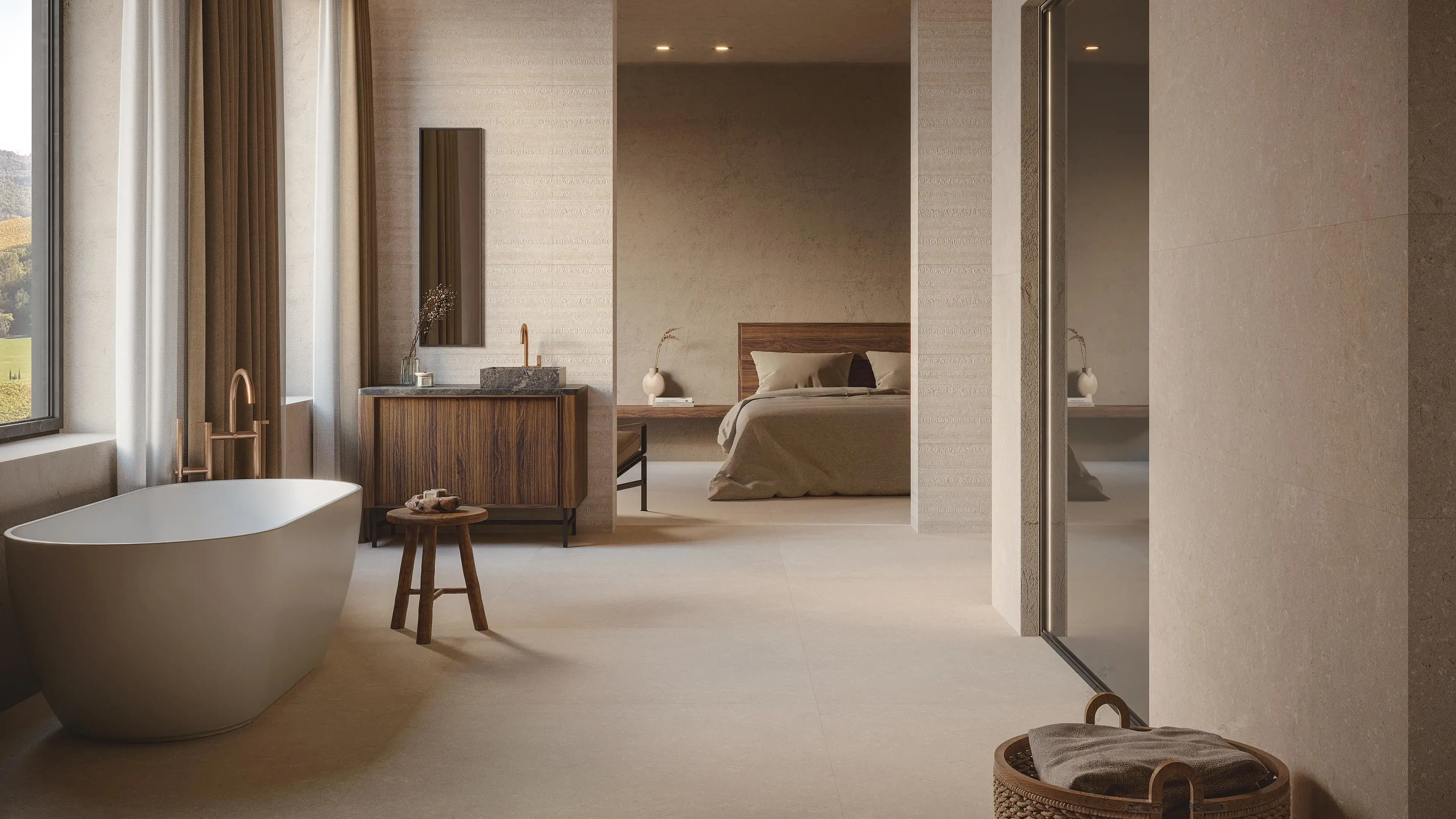 Spiga Coral Caliza wandtegel van Porcelanosa in badkamer met vrijstaand bad en gouden kraan