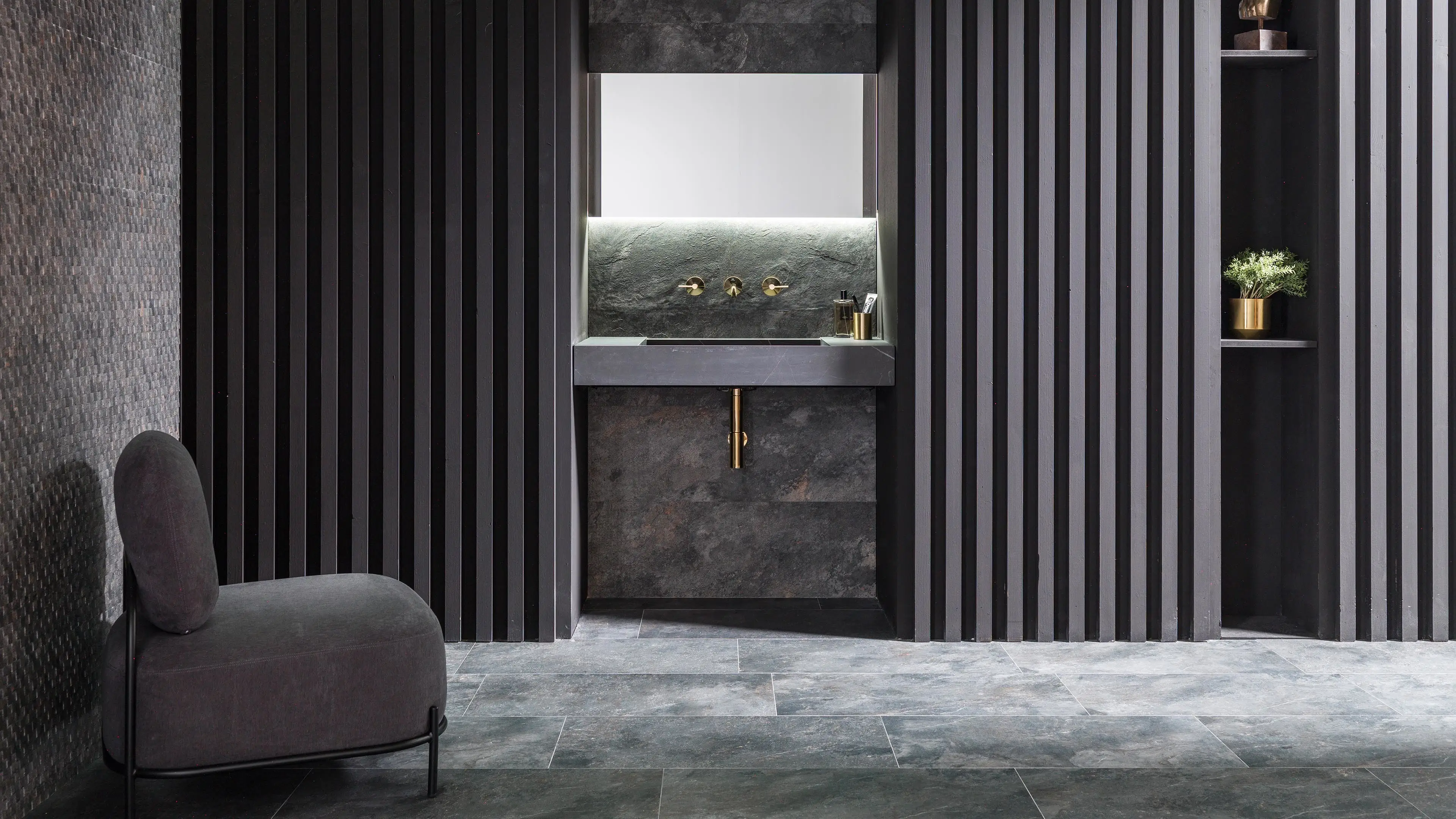 Porcelanosa Image Dark tegel in een donkere badkamer met stenen wastafel en gelamelleerde wand