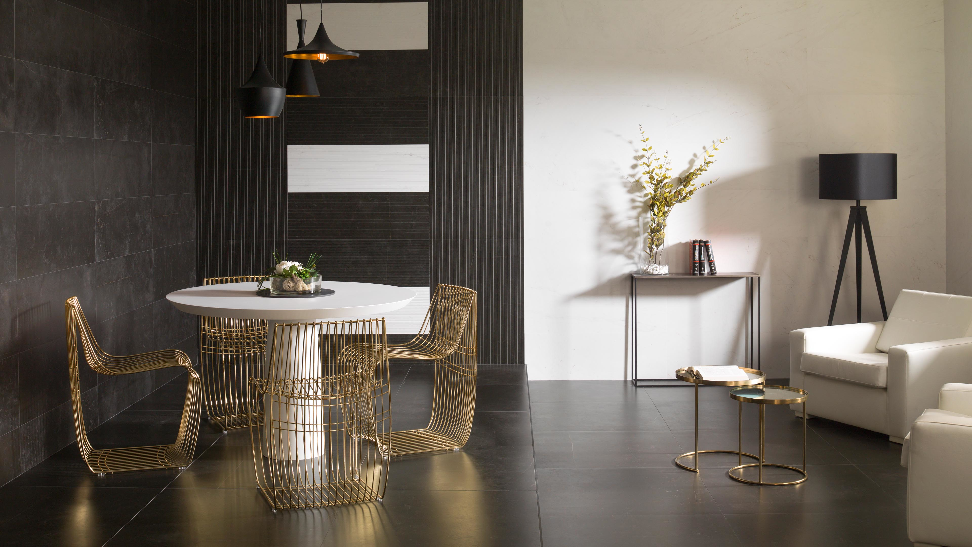 Eetkamer met Porcelanosa Magma Black wandtegel, ronde tafel en gouden stoelen