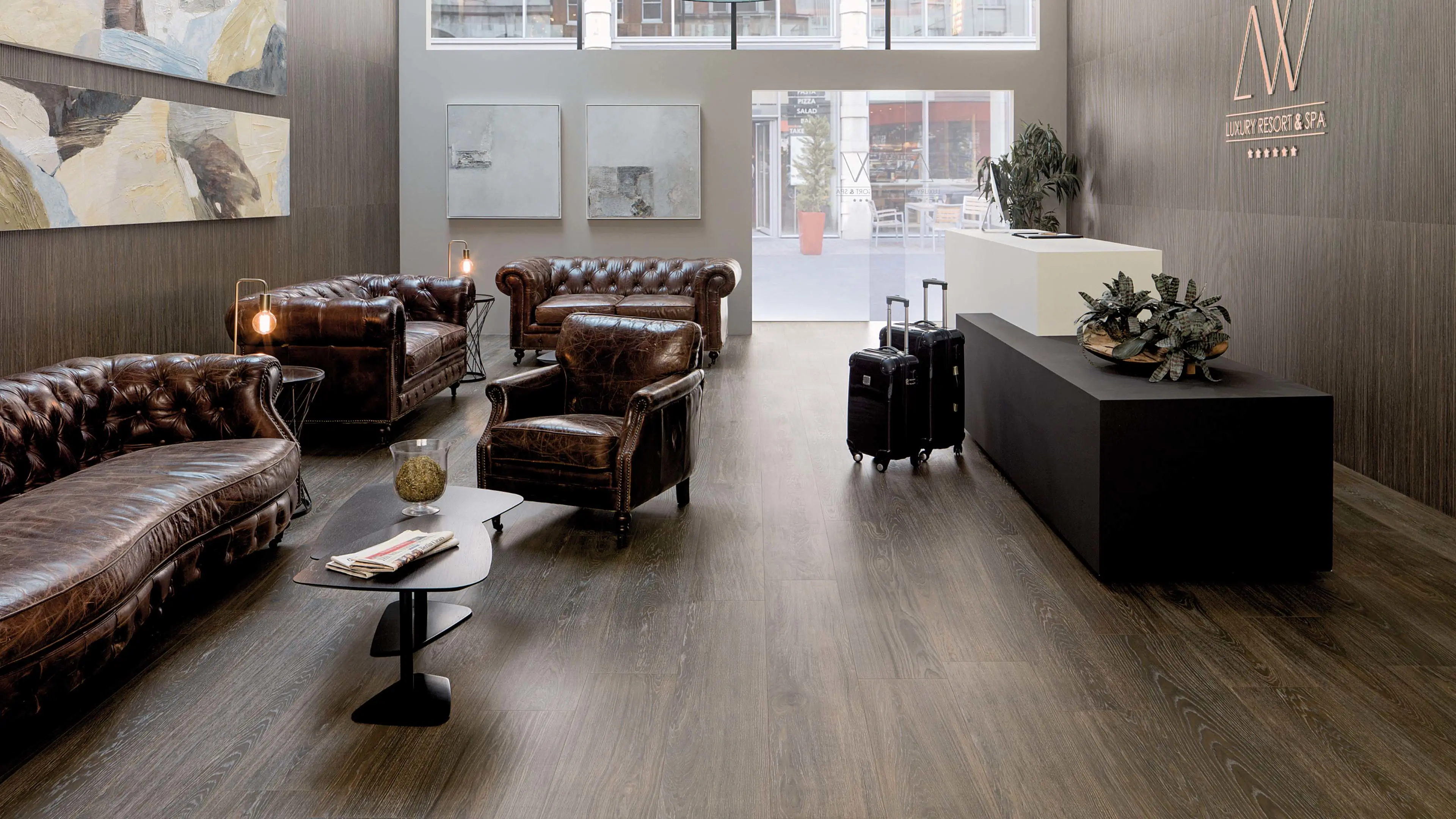 Lounge met Porcelanosa Minnesota Moka houtlook vloertegel en leren chesterfield fauteuils