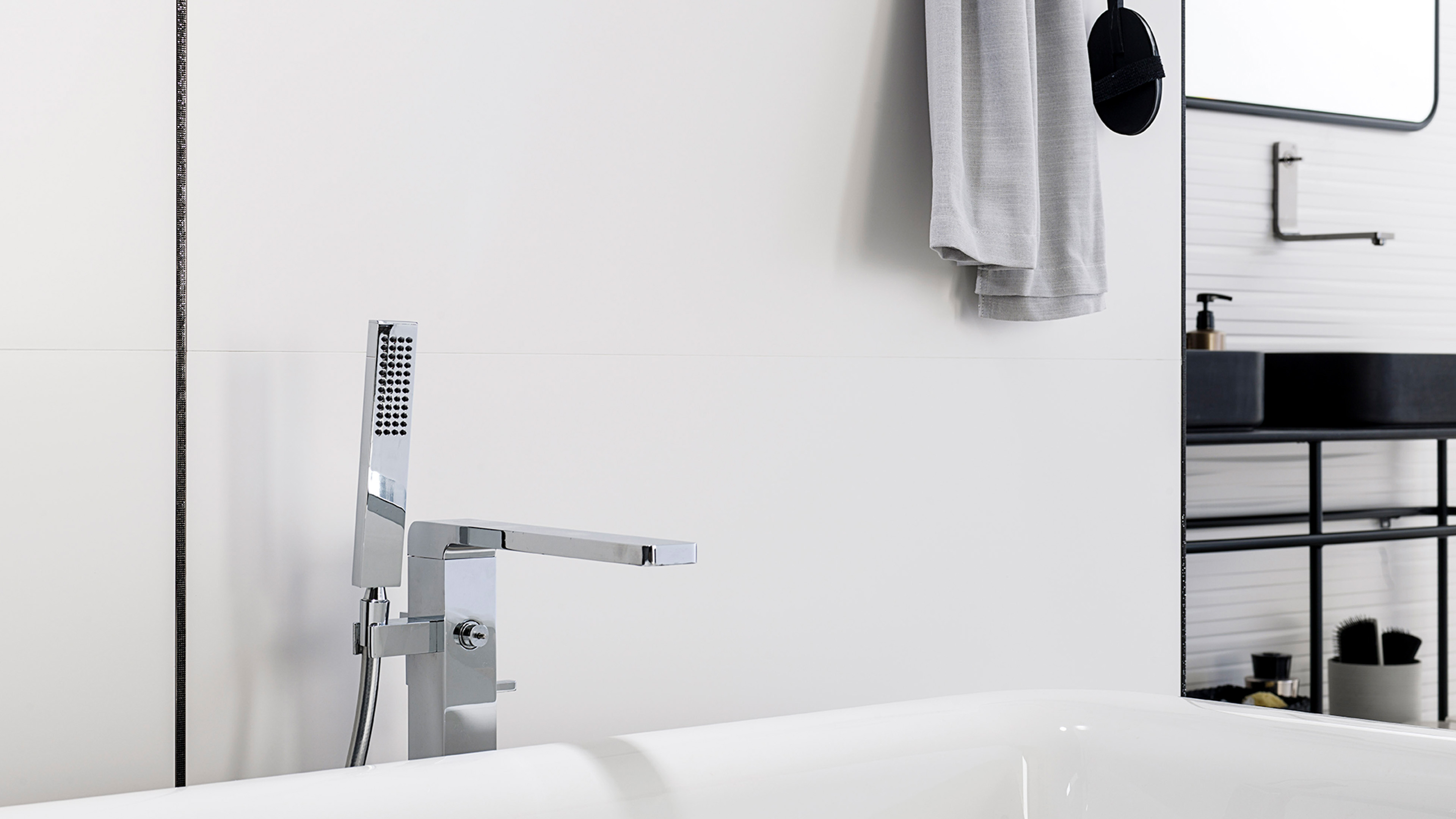 Badkamer met witte Porcelanosa Marmi Blanco wandtegel en ligbad met chromen badkraan