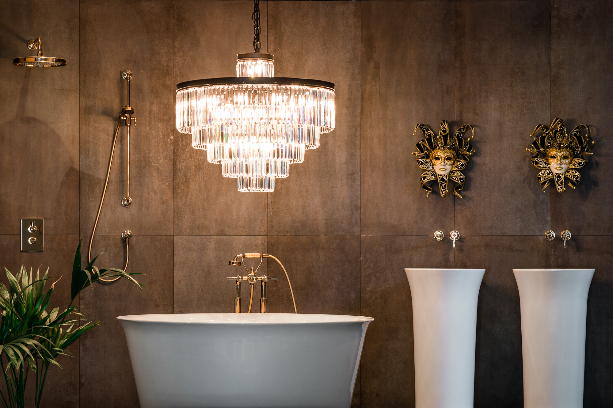 Luxe badkamerstyling met kristallen kroonluchter, vrijstaand bad en gouden badkraan