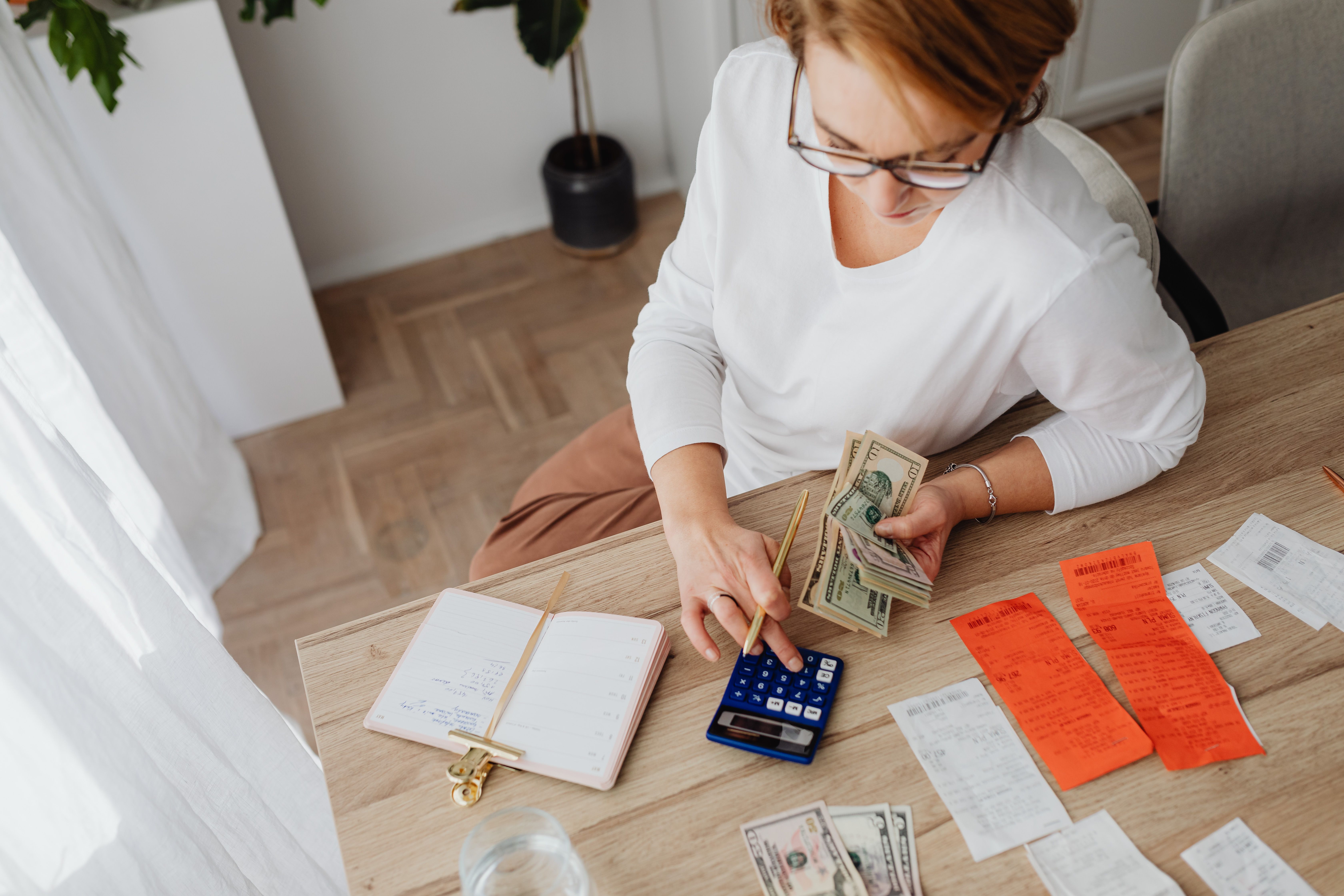 Persona comparando costos de envío de dinero a México con efectivo y una calculadora