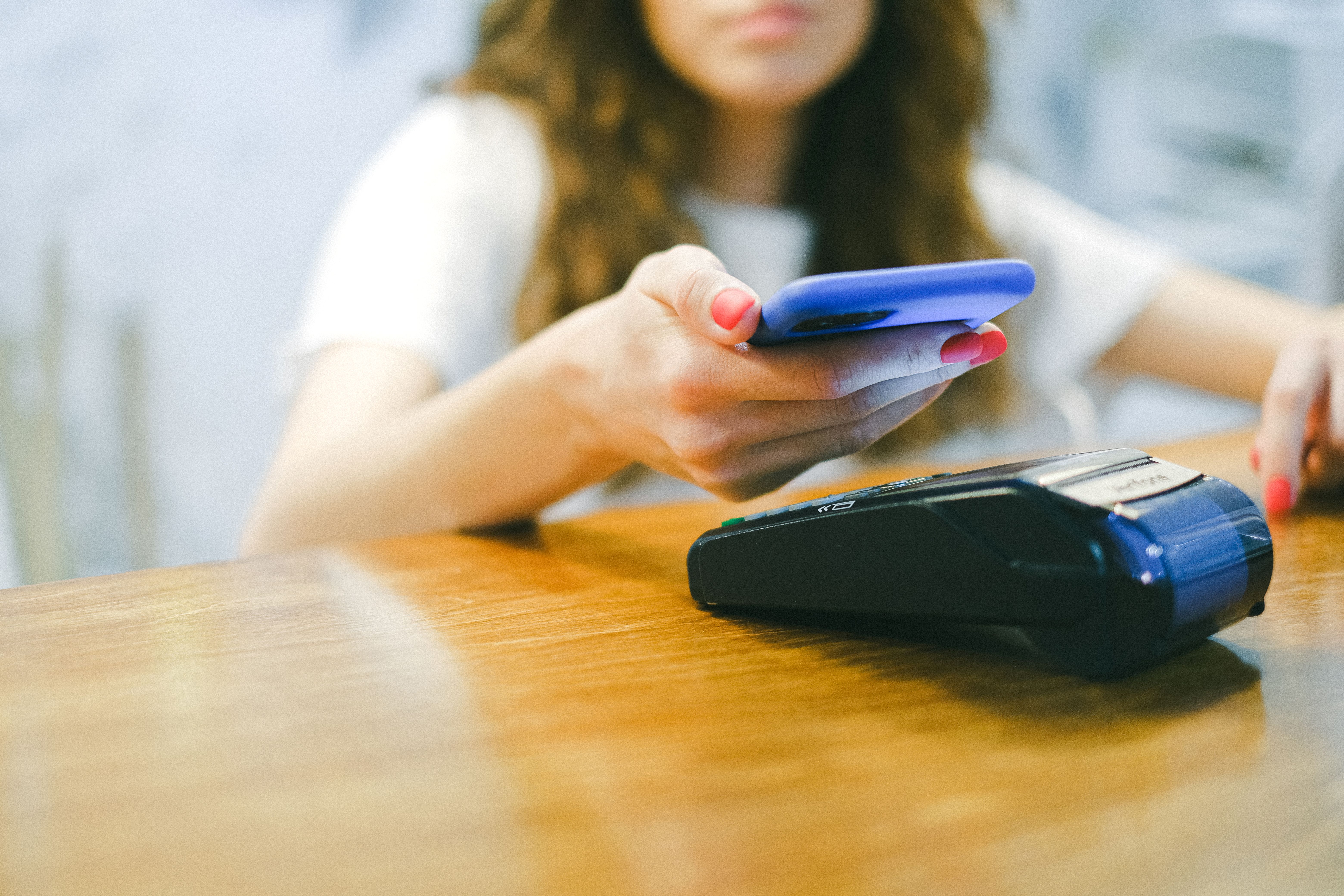 Mujer usando un teléfono para pagar con una billetera digital