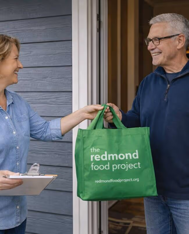 A food donor and a neighborhood coordinator passing a green bag.