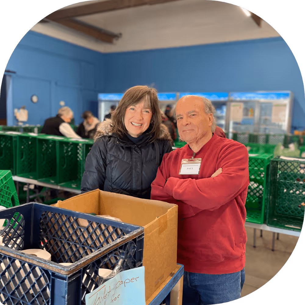 Two volunteers standing with donated food at Saint Vincent de Paul.