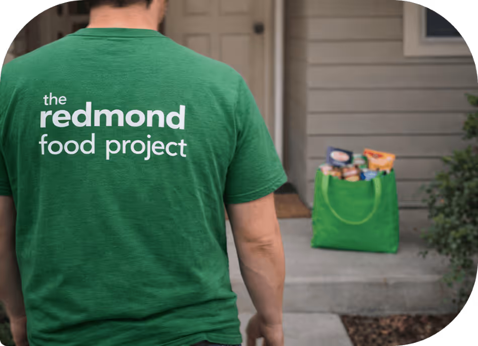 A neighborhood coordinator picking up donated food at the front porch of a food donor.