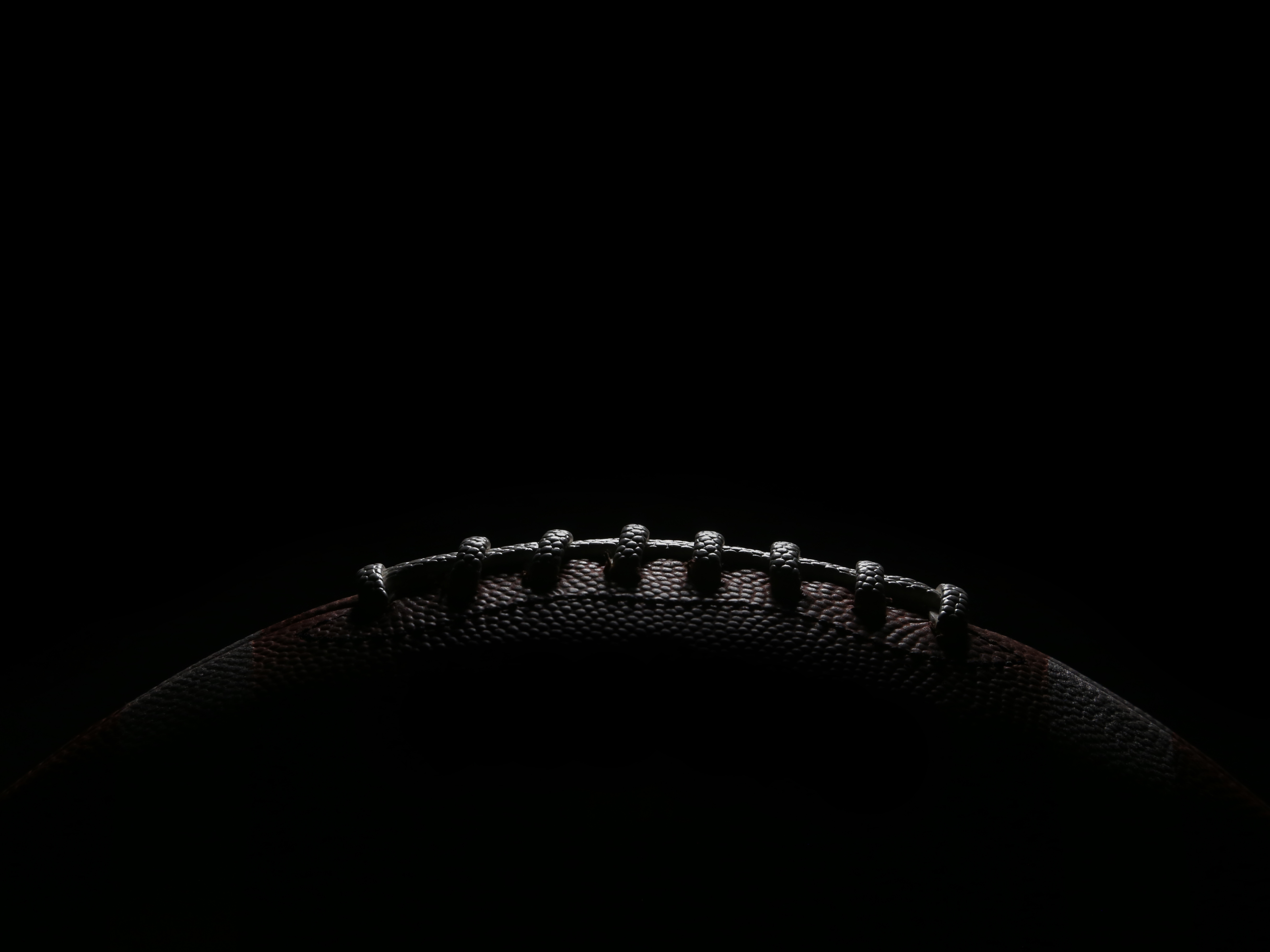 Football emerging from the dark