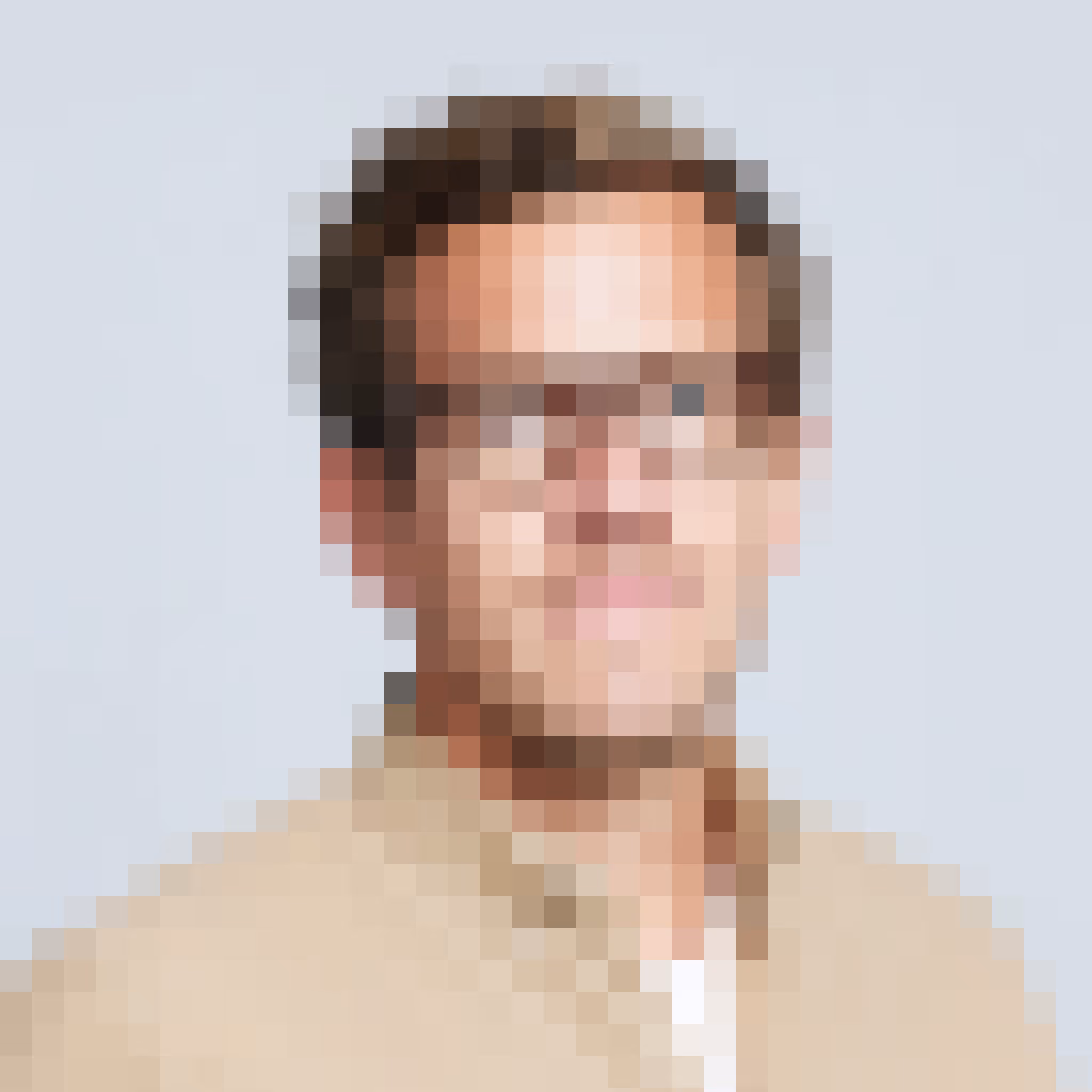 Portrait of a man wearing glasses and a beige shirt against a light background.