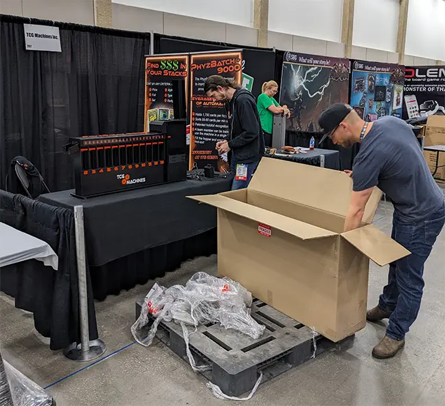 TCG Machines - John and Dan getting the booth set up for the 2024 GAMA Expo