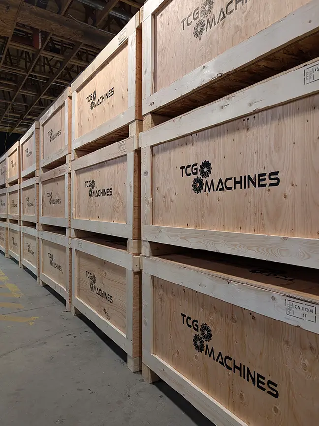 Stacks of TCG Machines shipping crates stretch into the distance