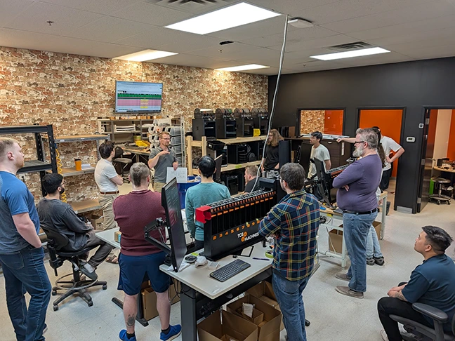TCG Machines team members during a production stand-up meeting