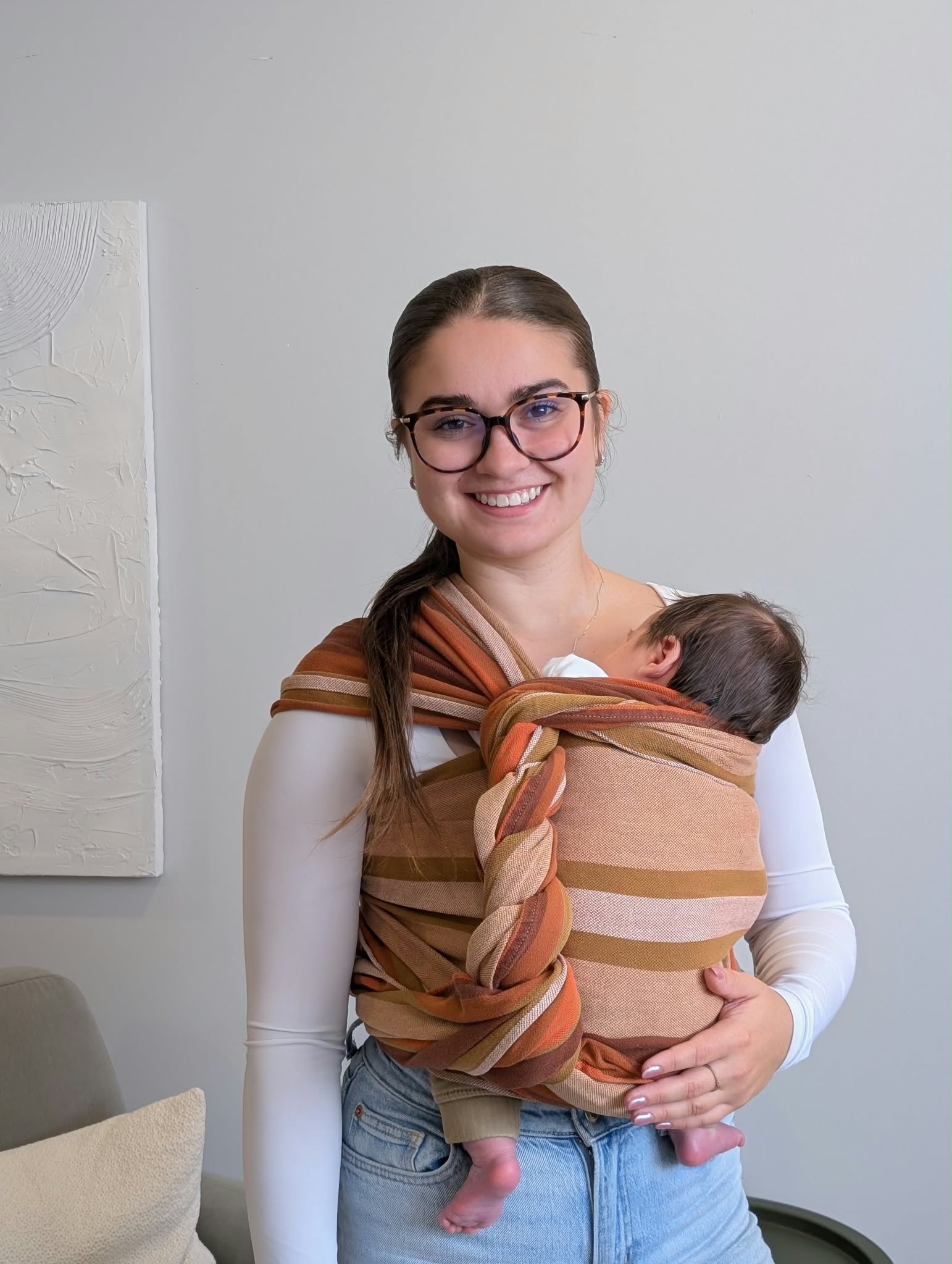 Émy Bonneau, éducatrice spécialisée, portant un nouveau-né en écharpe tissée