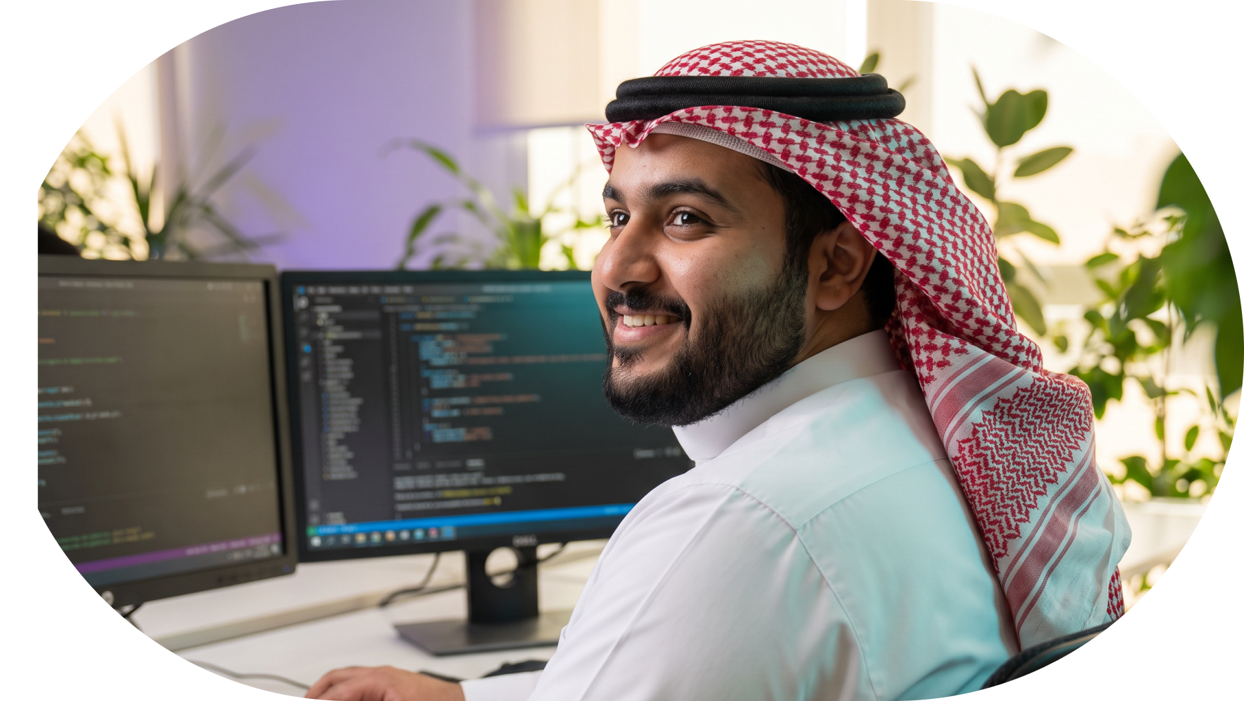 Man in traditional Middle Eastern attire working on a laptop in a modern office.