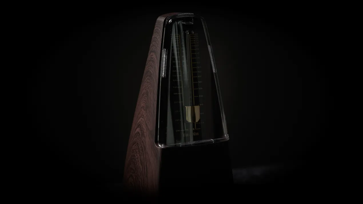 Klassisches Metronom im Dunkeln, das die taktische Kontrolle von Tempo und Rhythmus in der Verhandlung symbolisiert – DEADLOCK.