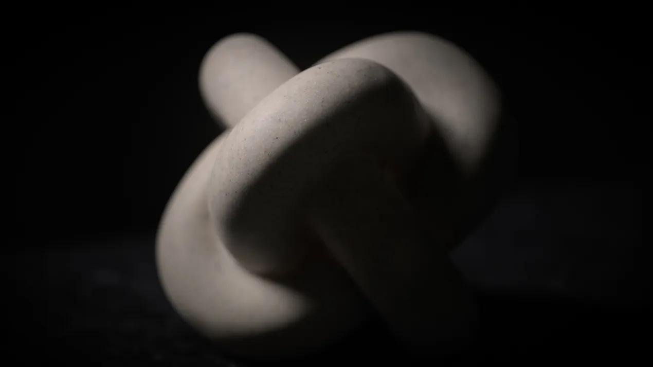 Steinerner Knoten im Schatten als Symbol für komplexe psychologische Dynamiken und den Entscheidungs-Deadlock.
